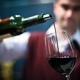 man pouring glass of wine